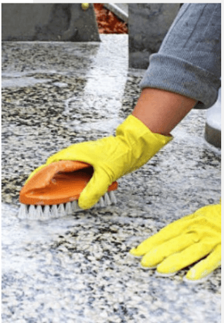 Using a brush and water to clean a granite headstone