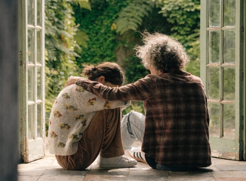 a warm natural photograph of two people sitting t
